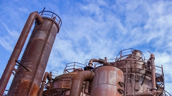 Eine fossile Industrieanlage vor blauem Himmel mit hellen Wolke